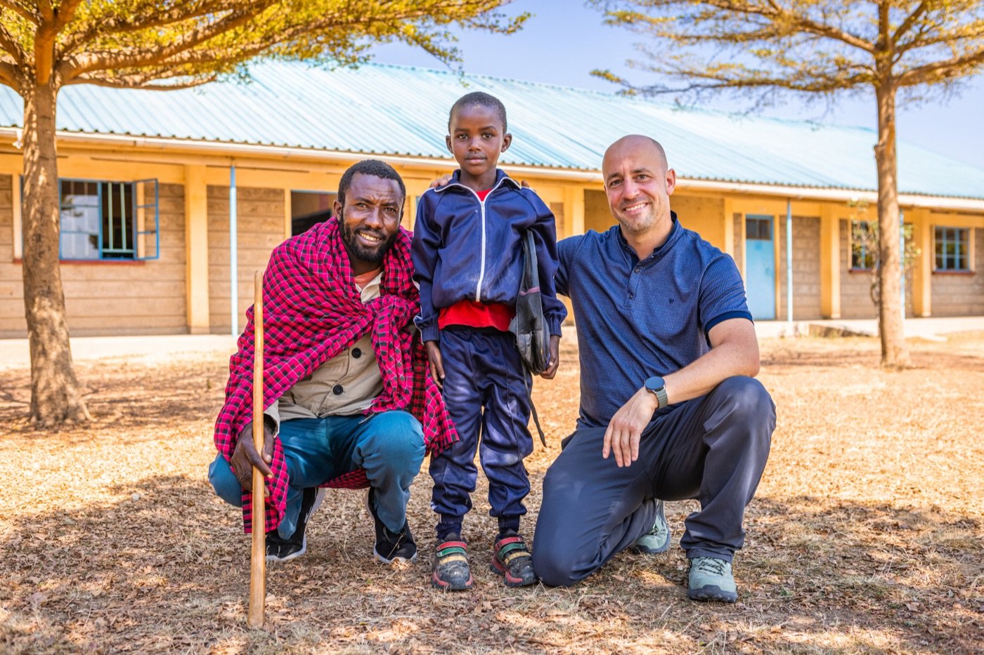 Mark with David of The Nairoshi Foundation and a Maasai schoolchild in front of the school